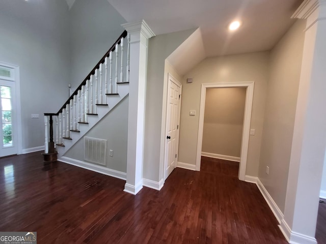 staircase with wood finished floors, visible vents, and baseboards