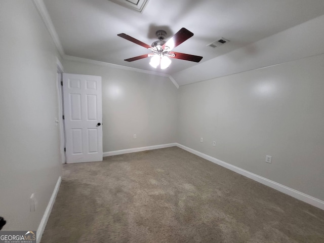 carpeted empty room with crown molding, visible vents, a ceiling fan, vaulted ceiling, and baseboards