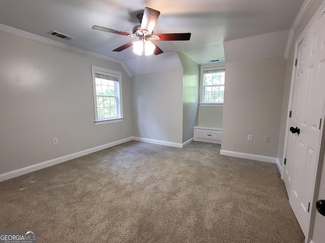 unfurnished bedroom with lofted ceiling, carpet floors, visible vents, baseboards, and crown molding