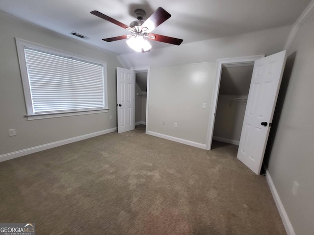 unfurnished bedroom with baseboards, visible vents, vaulted ceiling, and carpet flooring