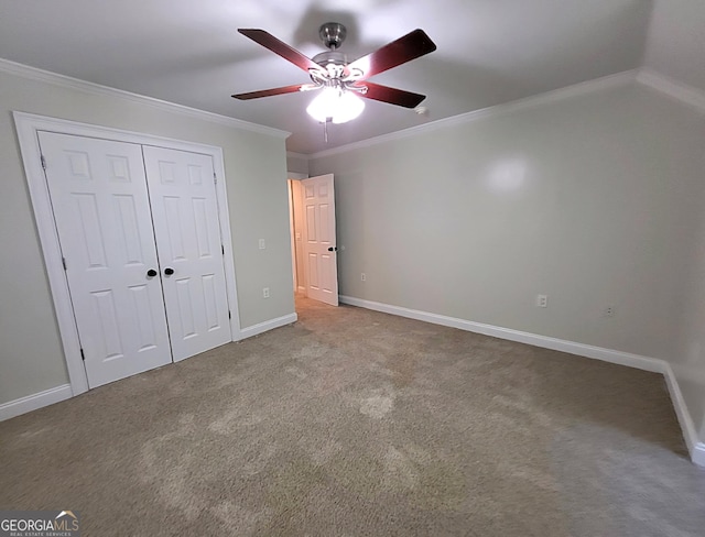 unfurnished bedroom with ornamental molding, carpet, a closet, and baseboards