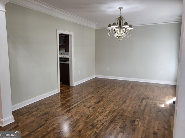 empty room with an inviting chandelier, baseboards, ornamental molding, and dark wood finished floors