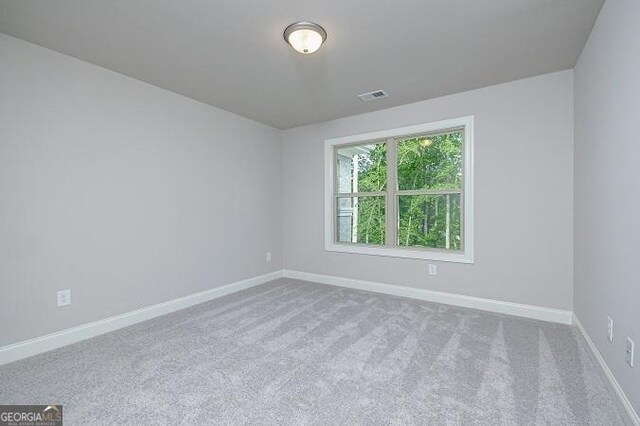 hall with beam ceiling, light carpet, crown molding, and coffered ceiling