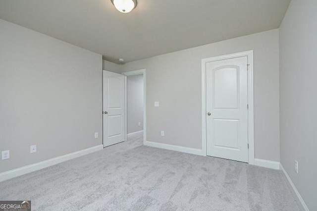 unfurnished room featuring light carpet