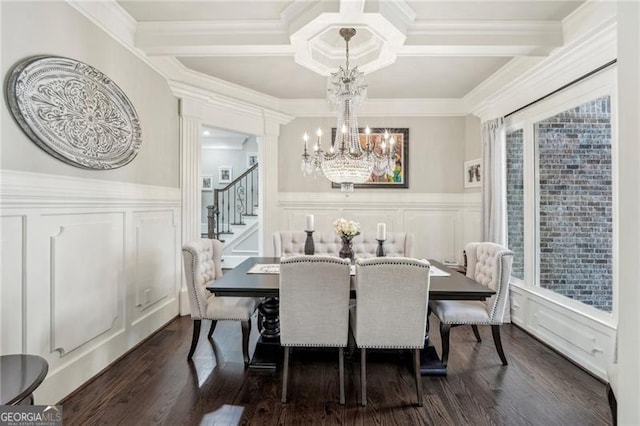 dining room with a decorative wall, a notable chandelier, dark wood-style flooring, coffered ceiling, and crown molding