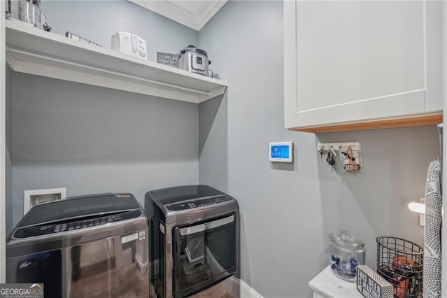 laundry area featuring washing machine and clothes dryer and cabinet space