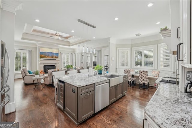 kitchen featuring beverage cooler, stainless steel appliances, a fireplace, open floor plan, and decorative light fixtures