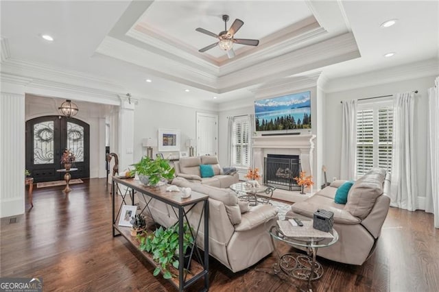 living room with ornamental molding, dark hardwood / wood-style floors, and a tray ceiling