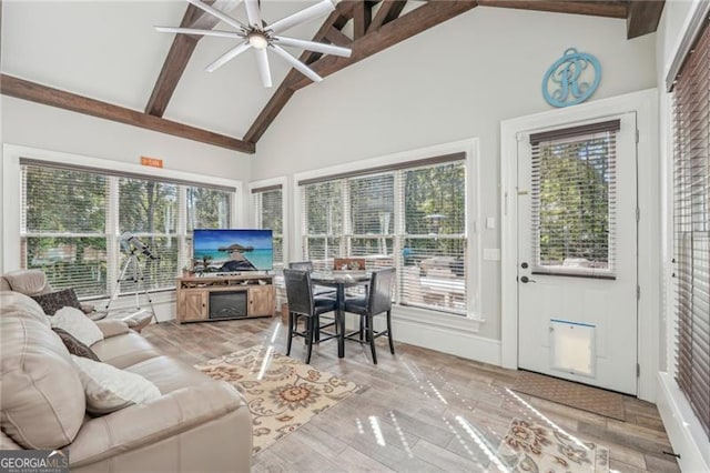 sunroom / solarium featuring vaulted ceiling with beams and a ceiling fan