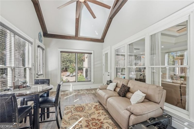 sunroom featuring lofted ceiling with beams and ceiling fan