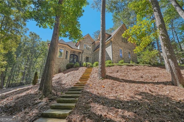 view of front facade with stairs and stone siding