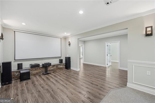 home theater room featuring recessed lighting, wood finished floors, visible vents, baseboards, and crown molding