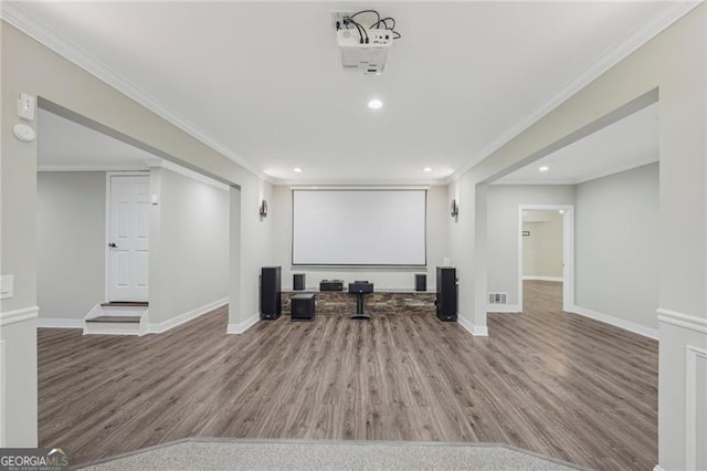 home theater featuring crown molding, baseboards, and wood finished floors