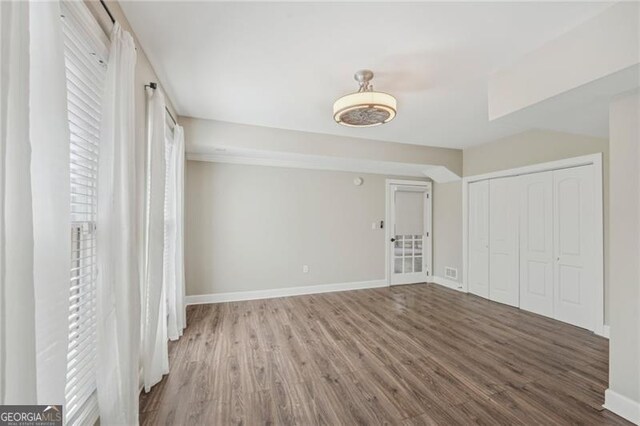 unfurnished room with dark hardwood / wood-style flooring