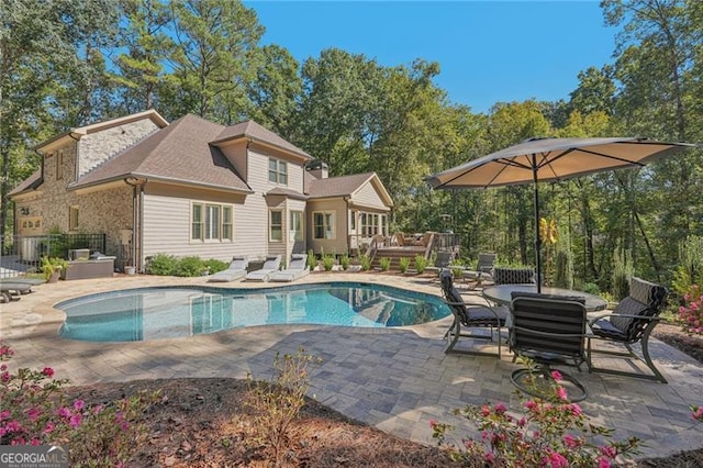 view of pool featuring a wooden deck and a patio area