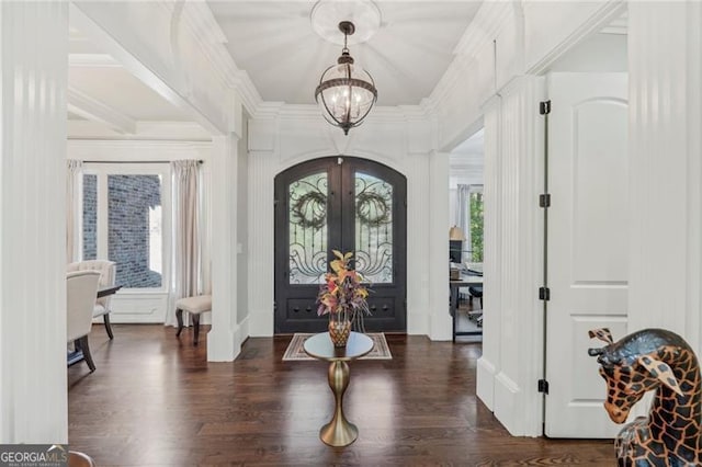 entrance foyer featuring a notable chandelier, ornamental molding, dark wood-style flooring, and french doors