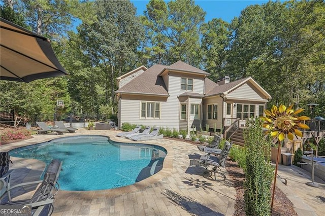 view of pool with a fenced in pool, a patio area, fence, and stairs