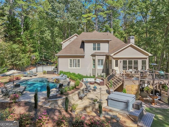 back of property featuring a fenced in pool, a chimney, stairway, fence, and a wooden deck