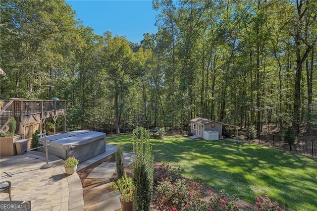 view of yard featuring a hot tub, a patio area, fence, a shed, and an outdoor structure