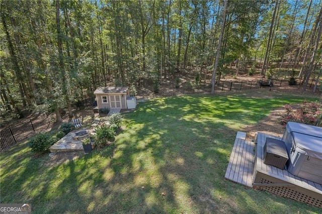 view of yard featuring a storage unit, an outdoor structure, fence, and a wooden deck