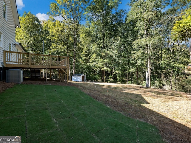 view of yard featuring a wooden deck, central AC unit, and a storage unit