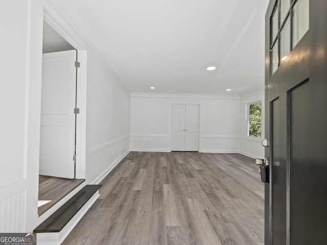 foyer with light hardwood / wood-style flooring and ornamental molding