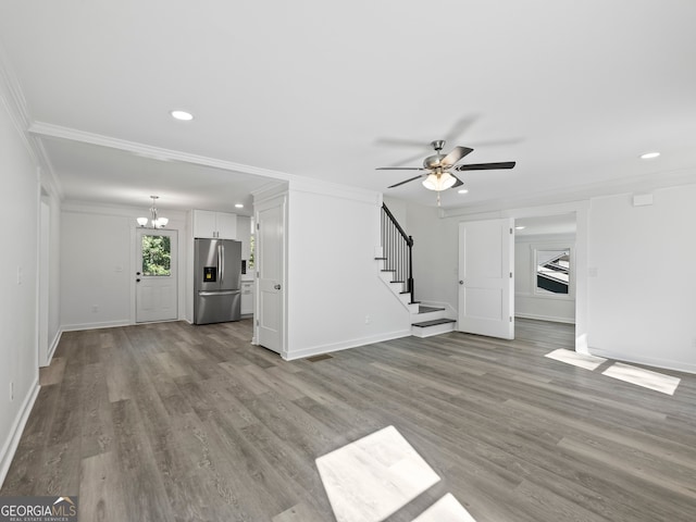 unfurnished living room featuring ceiling fan with notable chandelier, light hardwood / wood-style floors, and ornamental molding