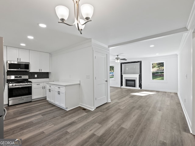 kitchen featuring white cabinets, hardwood / wood-style floors, stainless steel appliances, and crown molding