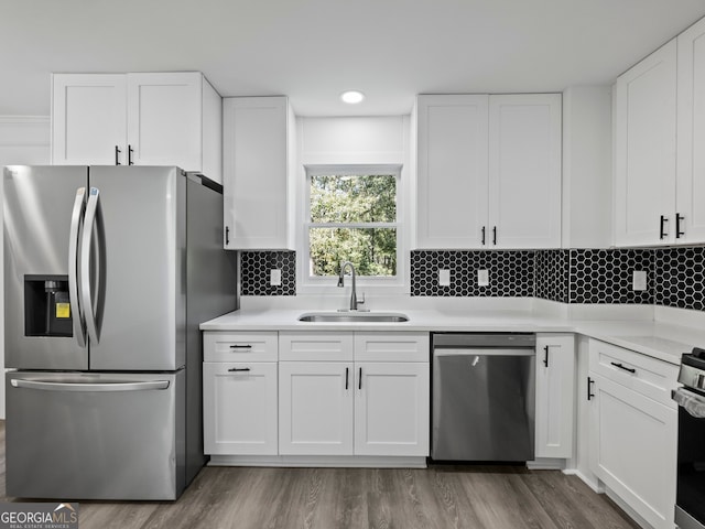 kitchen with white cabinetry, sink, hardwood / wood-style flooring, and appliances with stainless steel finishes