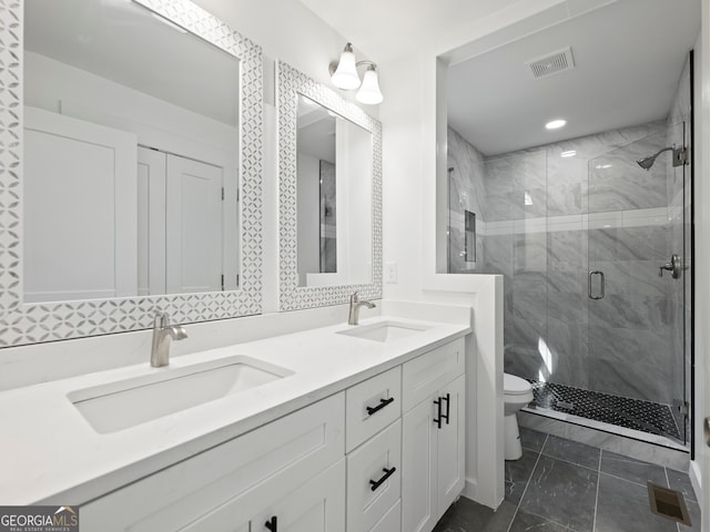 bathroom featuring vanity, a shower with shower door, and toilet