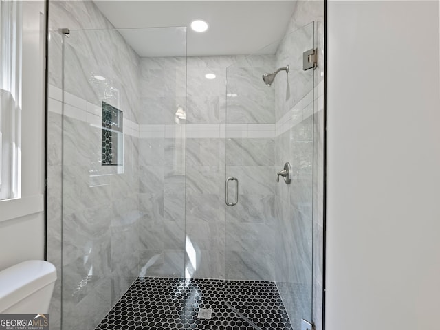 bathroom with an enclosed shower and toilet