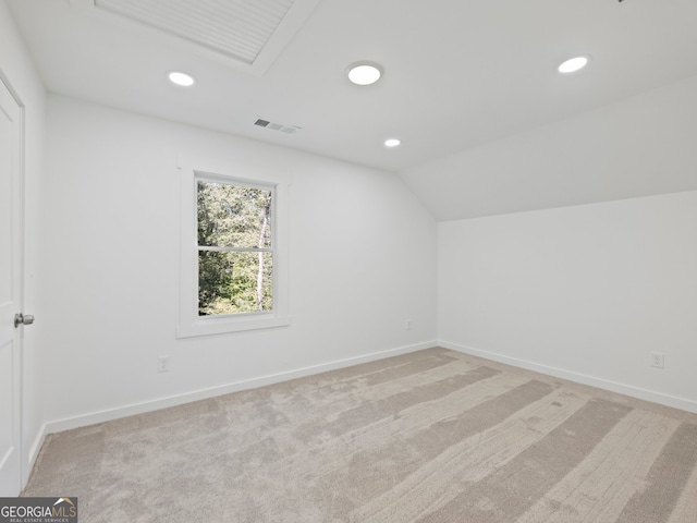 additional living space with light colored carpet and vaulted ceiling