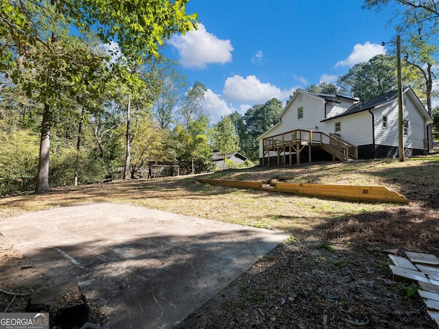 view of yard featuring a patio and a wooden deck