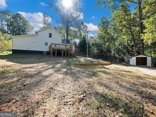 view of yard with a wooden deck and a storage shed