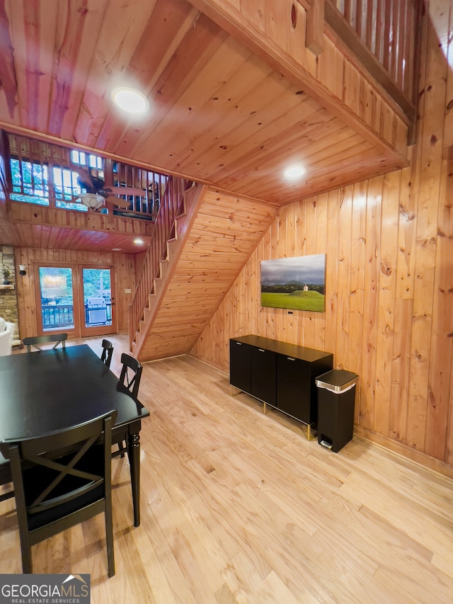 dining room with wood ceiling, wood walls, wood-type flooring, and vaulted ceiling