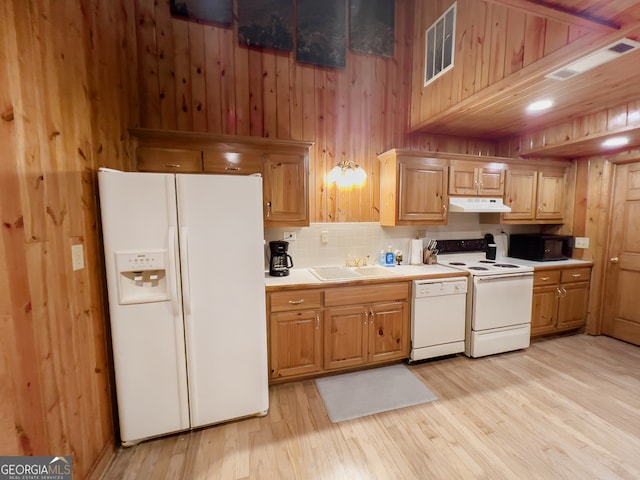 kitchen with white appliances, light hardwood / wood-style floors, sink, and wooden walls