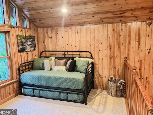 bedroom featuring multiple windows, wood walls, wooden ceiling, and lofted ceiling