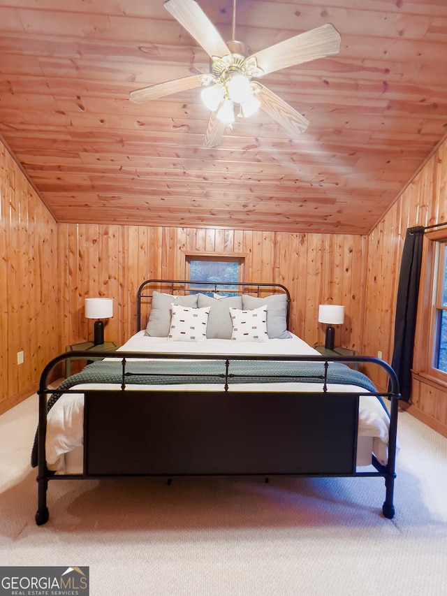 unfurnished bedroom featuring ceiling fan, wooden walls, and light colored carpet