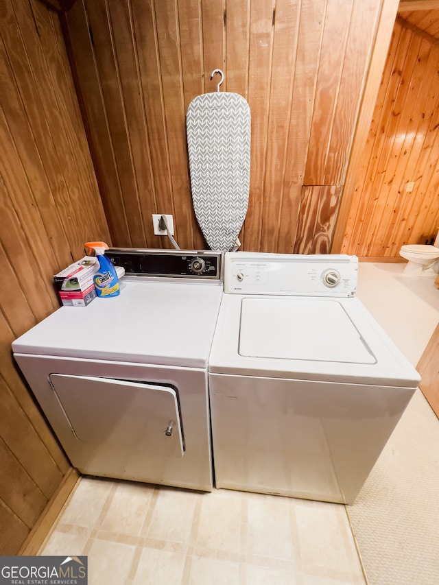 washroom with wood walls and washer and clothes dryer