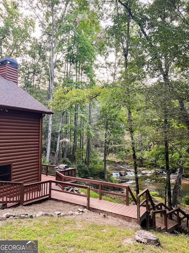 view of yard featuring a deck with water view