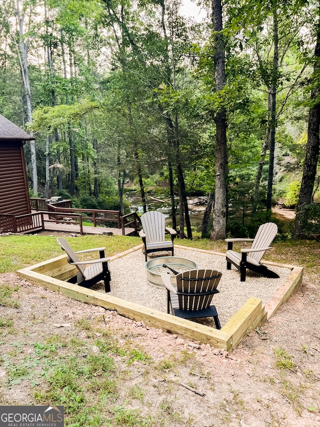 view of yard with a wooden deck and a fire pit