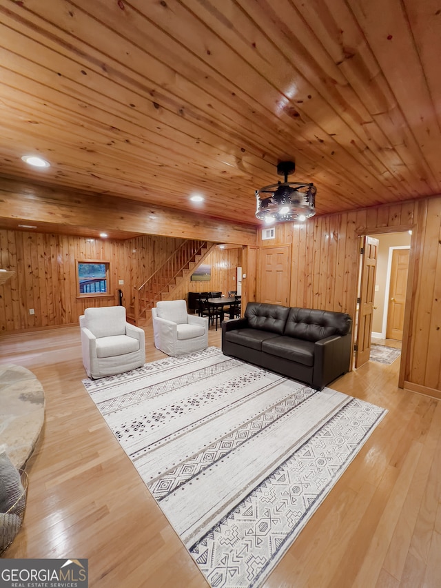 living room with ceiling fan, hardwood / wood-style flooring, wooden ceiling, and wood walls