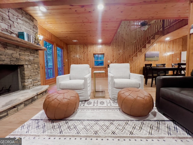 living room featuring wooden ceiling, a fireplace, light wood-type flooring, and wood walls