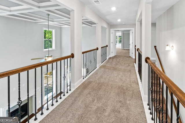 hallway featuring coffered ceiling, beam ceiling, and light carpet