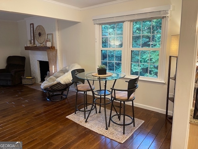 dining room with crown molding, a fireplace, and dark hardwood / wood-style floors