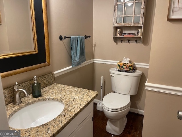 bathroom with vanity, hardwood / wood-style flooring, and toilet