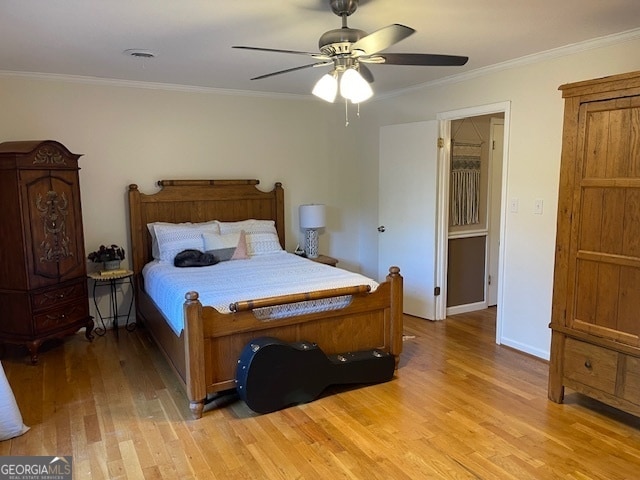 bedroom featuring light hardwood / wood-style floors, ornamental molding, and ceiling fan