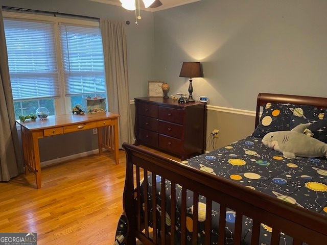 bedroom featuring crown molding and light hardwood / wood-style floors