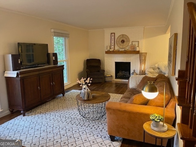 living room with light hardwood / wood-style floors, ornamental molding, and a fireplace