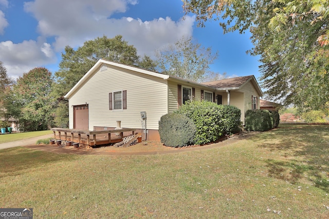 view of home's exterior with a garage, a lawn, and a deck